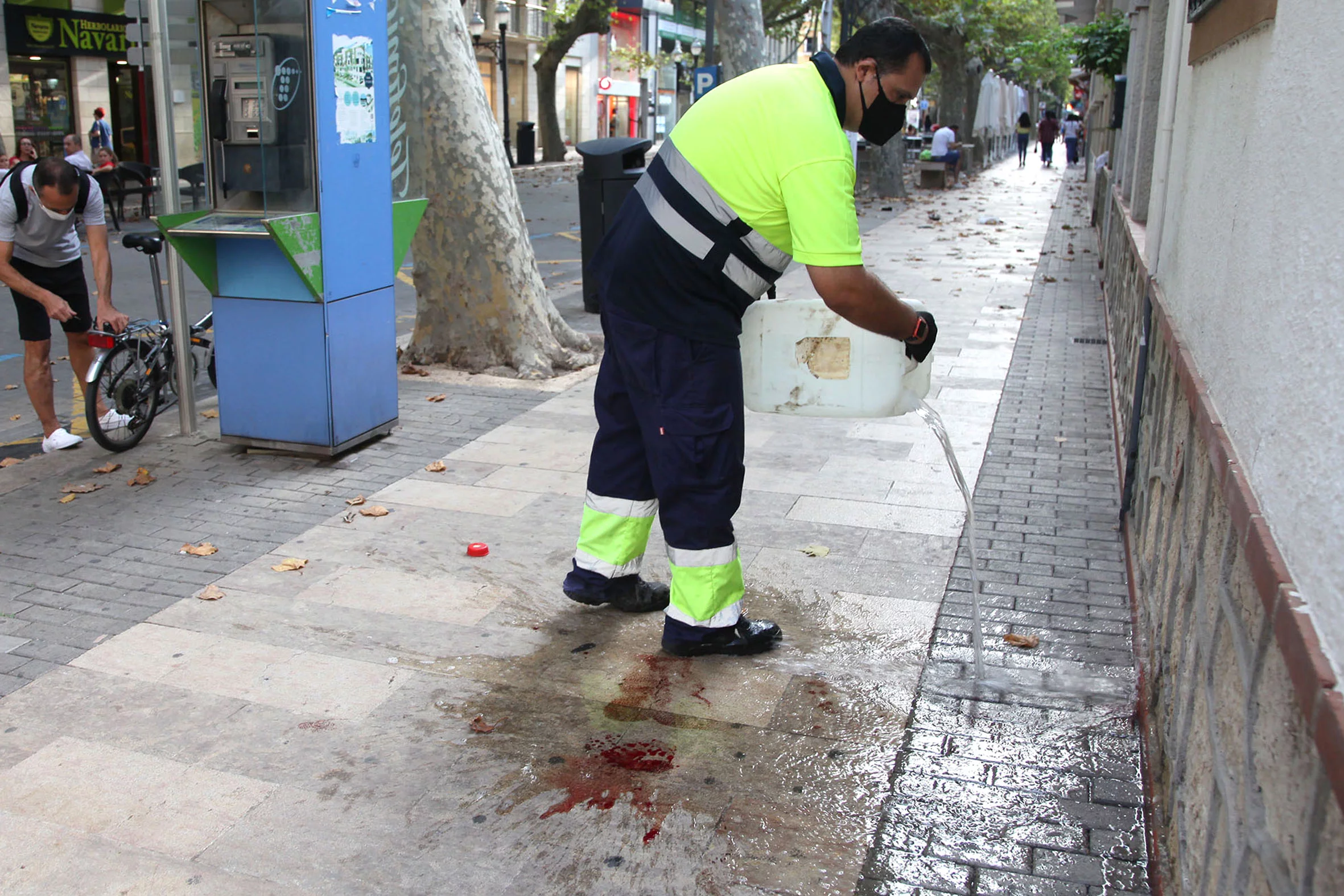 Personal de limpieza limpia la sangre de la calle