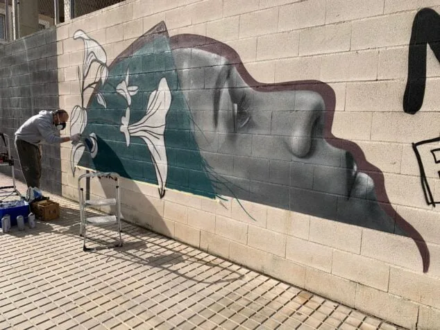Dénia reúne a muralistas para arreglar los grafitis de La Vía ensuciados por actos vandálicos 4 Imagen: Artista arreglando un mural víctima de actos vandálicos