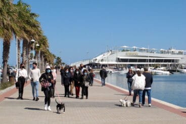 gente paseando por el puerto de denia con mascarillas