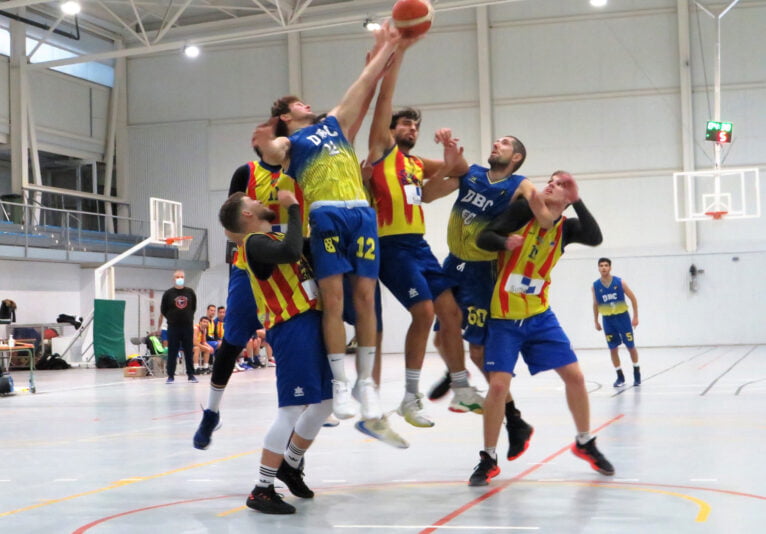 Dénia Básquet players competing for a ball at Altea