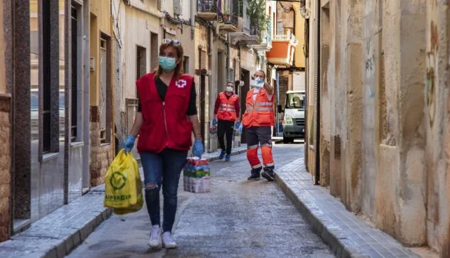Imatge: Voluntaris de Creu Roja lliurant aliments