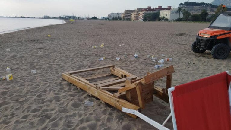 Basura y una silla de proximidad volcada en una playa de Dénia