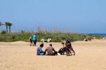 Familias disfrutando del día de Pascua en la extensa arena de la playa de Les Marines en Dénia.