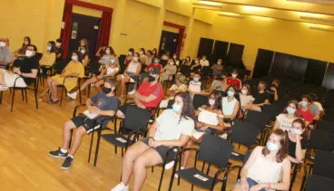 adolescentes sentados con distancia de seguridad durante lla clausura del curso de ciclomotor