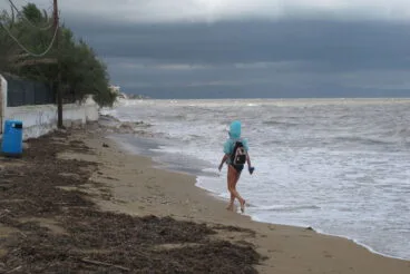 Bañista paseando junto al mar revuelto