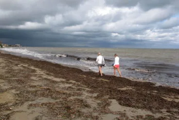 Pareja paseando por la orilla tras la tormenta