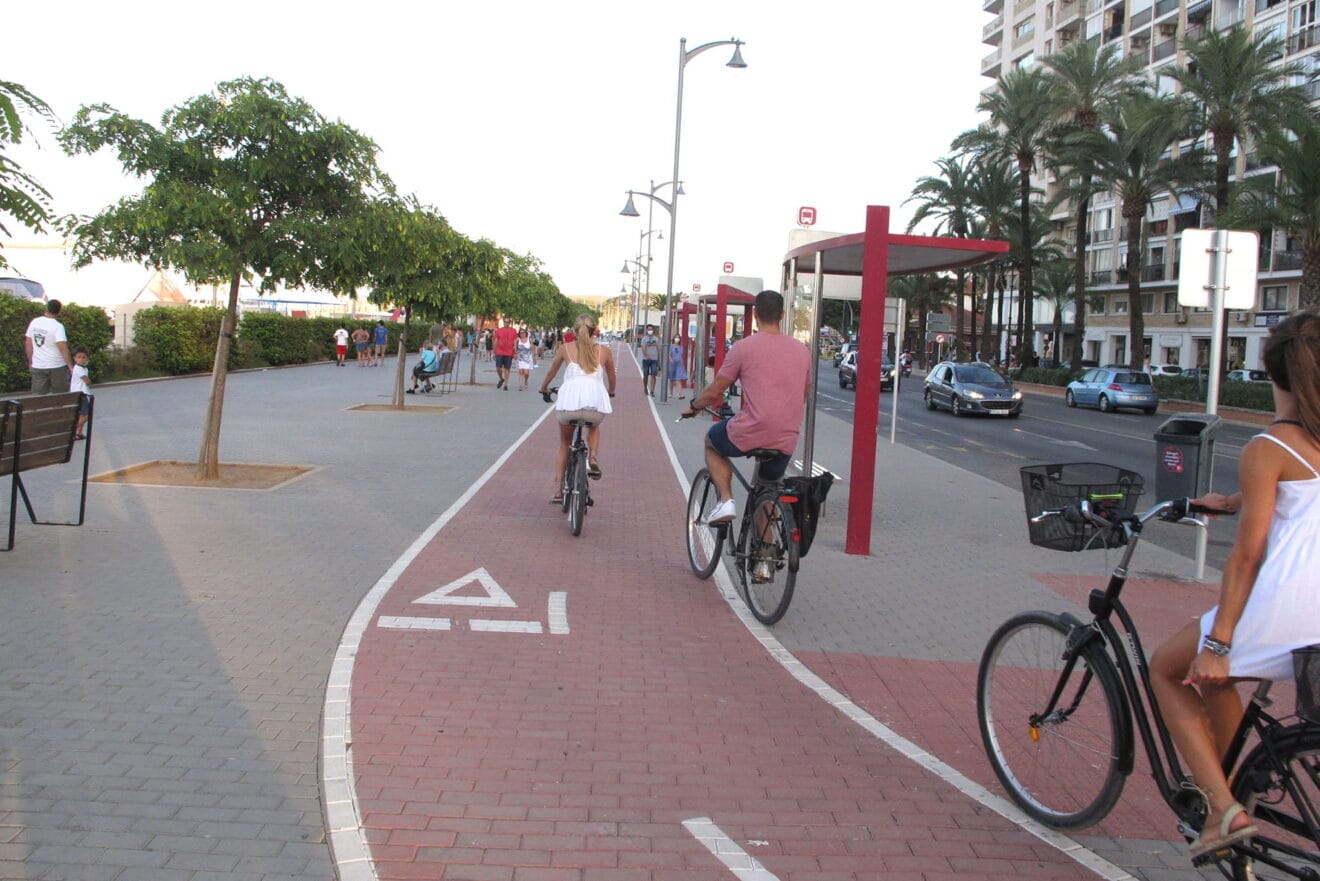 Turistas utilizando el carril bici del puerto de Dénia