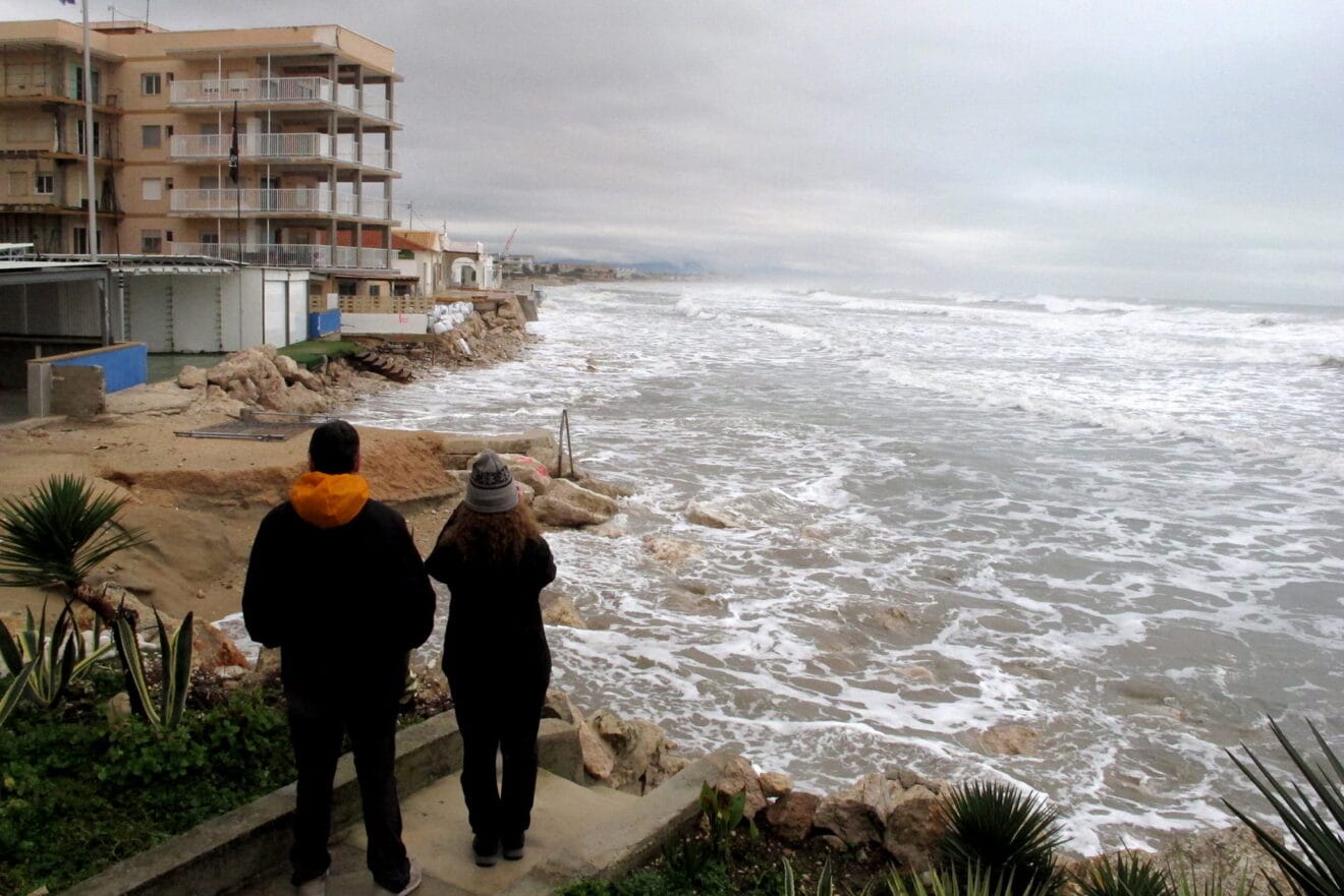 Vecinos observando los destrozos de la playa Les Deveses