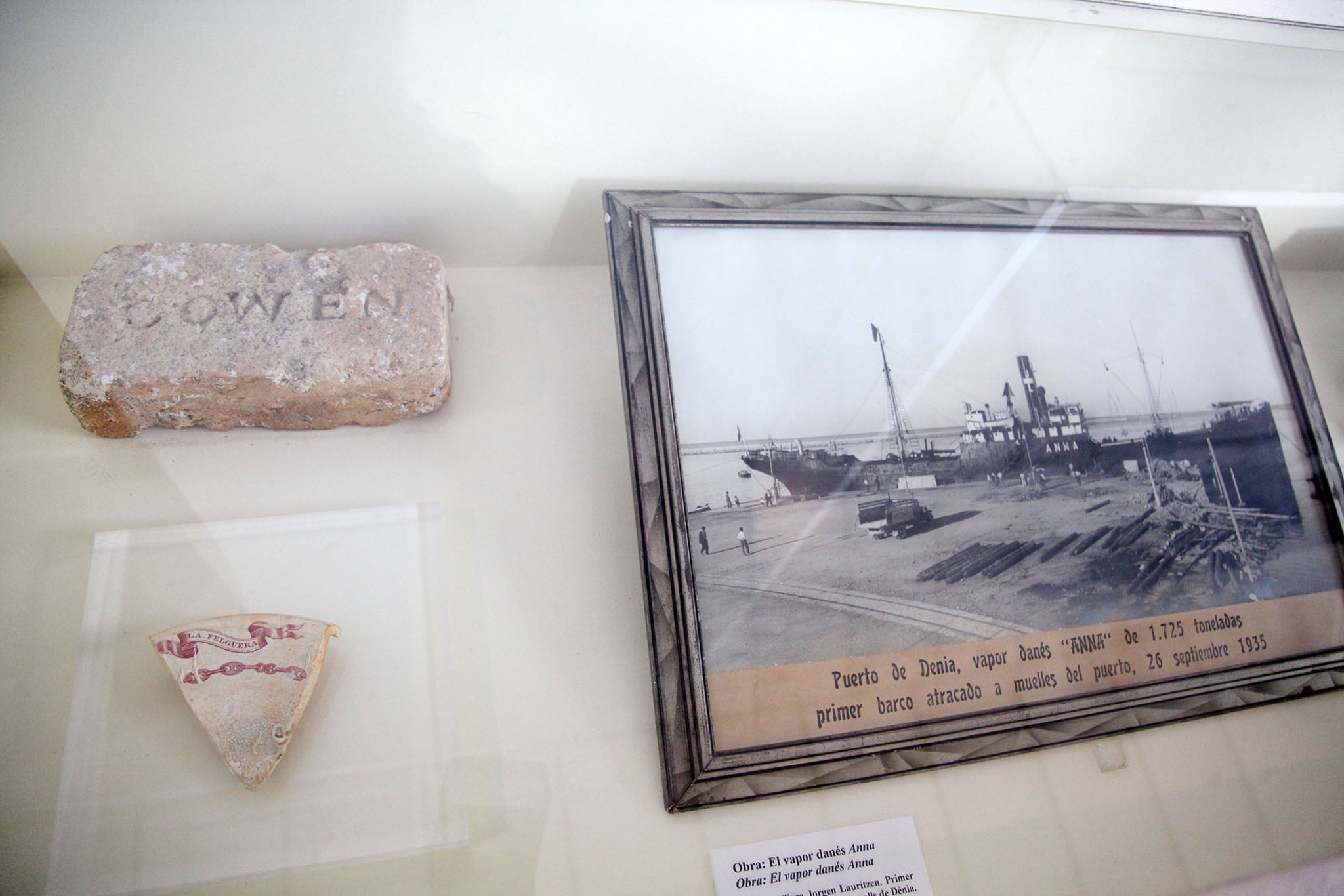 A la derecha, fotografía de primer barco en amarrar en los nuevos muelles de Dénia en 1935, y la izquierda, fragmento de plato con la leyenda %22La Felguera%22