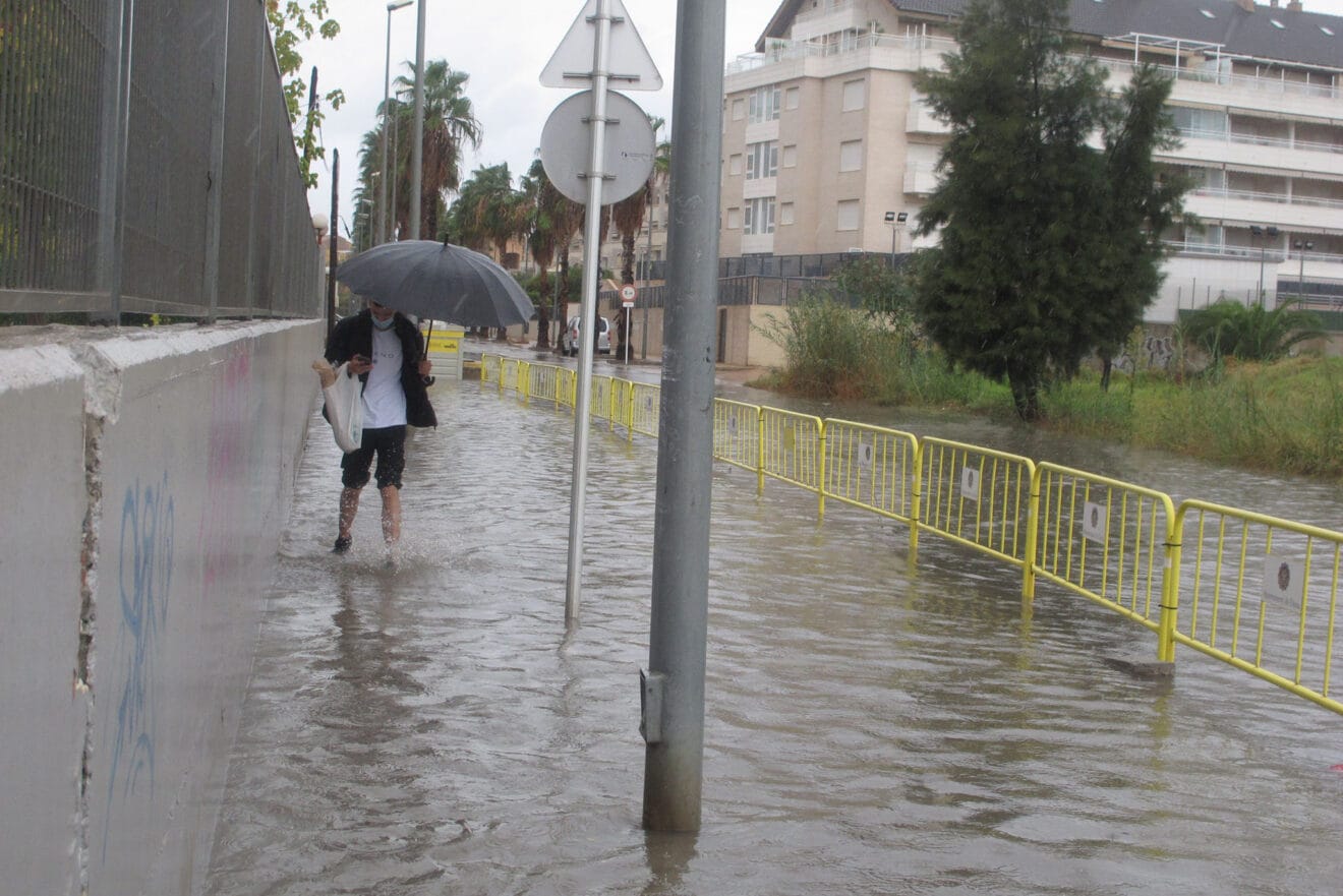 Vecino caminando por una carretera anegada por la lluvia