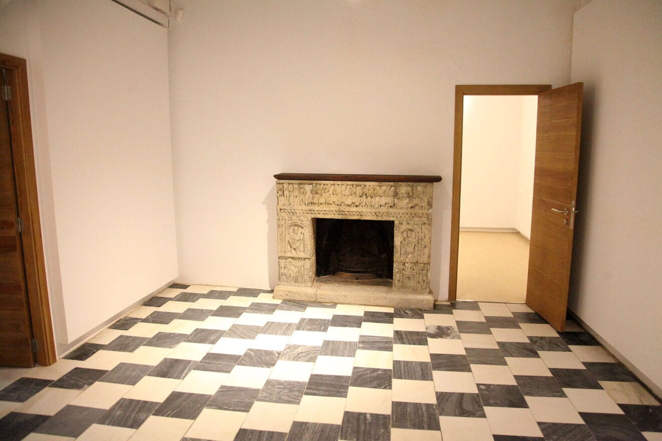 Chimenea en una habitación con escenas bélicas talladas