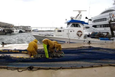 trabajadores del puerto de denia bajo la lluvia