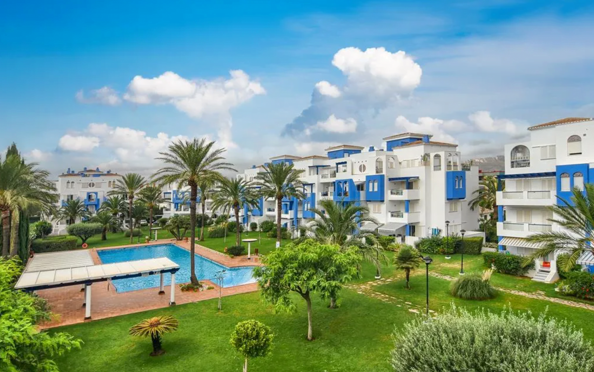 Gran jardín con piscina comunitaria del apartamento disponible con Aguila Rent a Villa