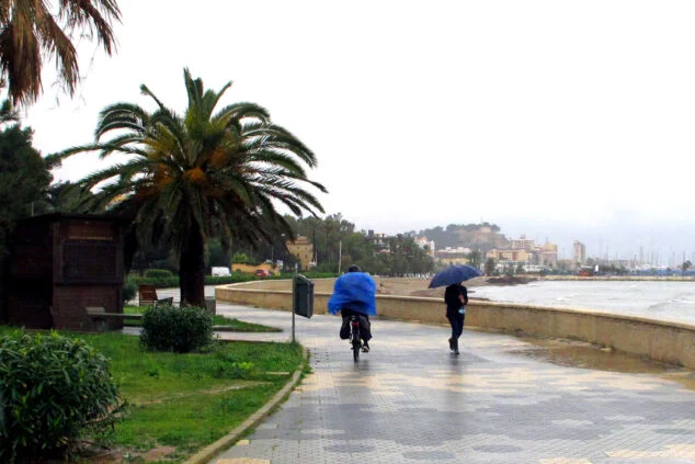 Bild: Nachbarn gehen im Nieselregen entlang der Marineta Cassiana