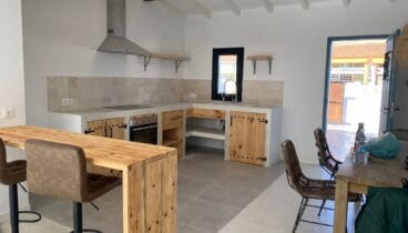 Cocina de estilo rústico con microcemento y puertas en madera