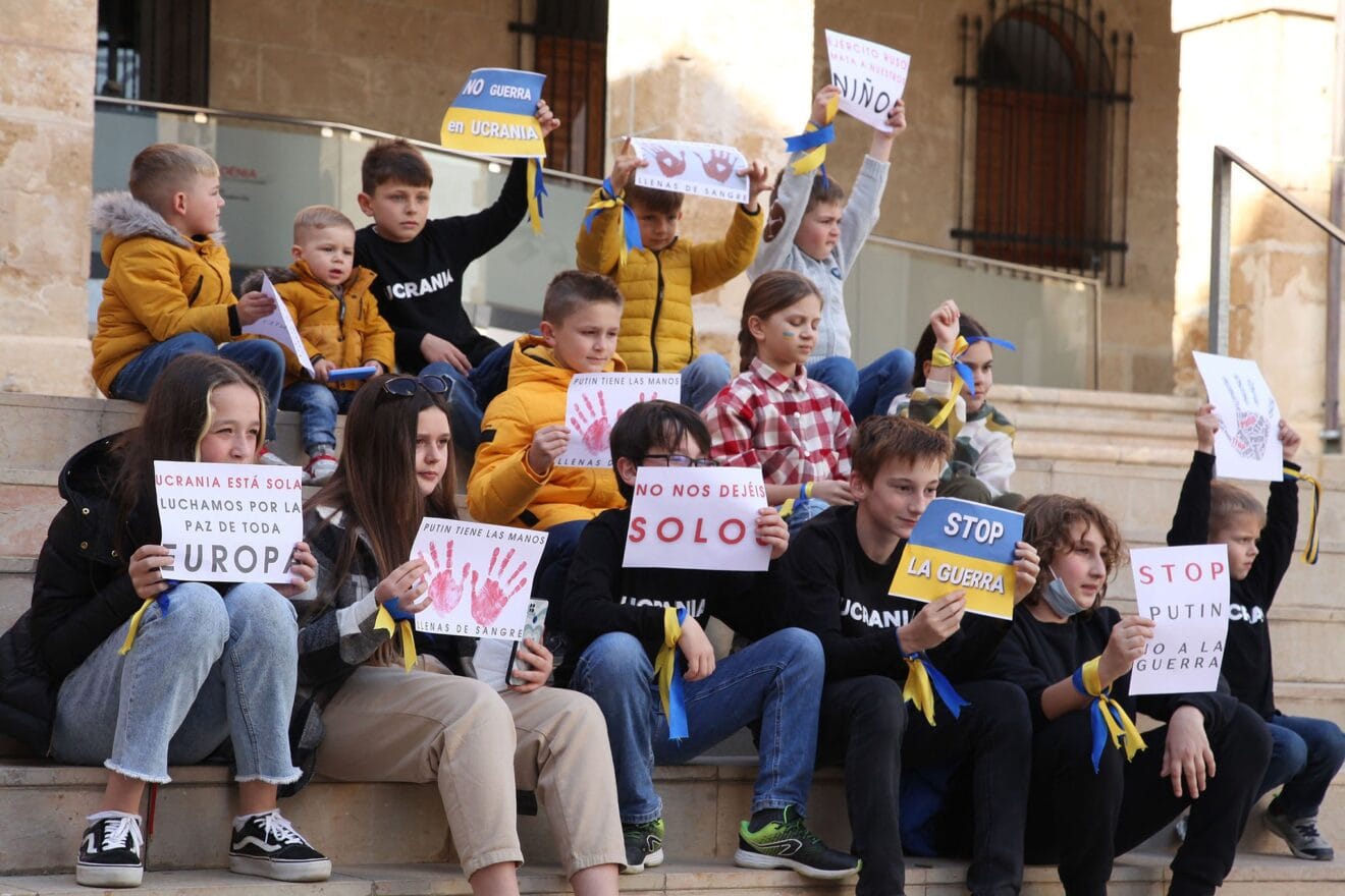 Los niños y niñas alzando pancartar contra la guerra