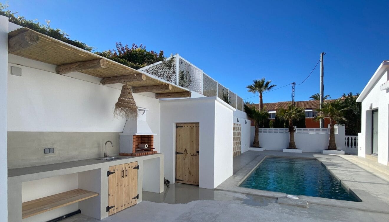Piscina de la casa con cocina exterior y barbacoa