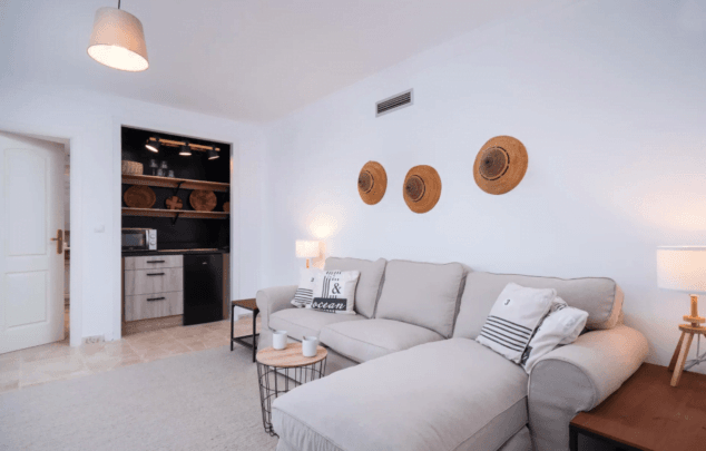 sala de estar con cocina y tele en esta villa de aguila rent a villa