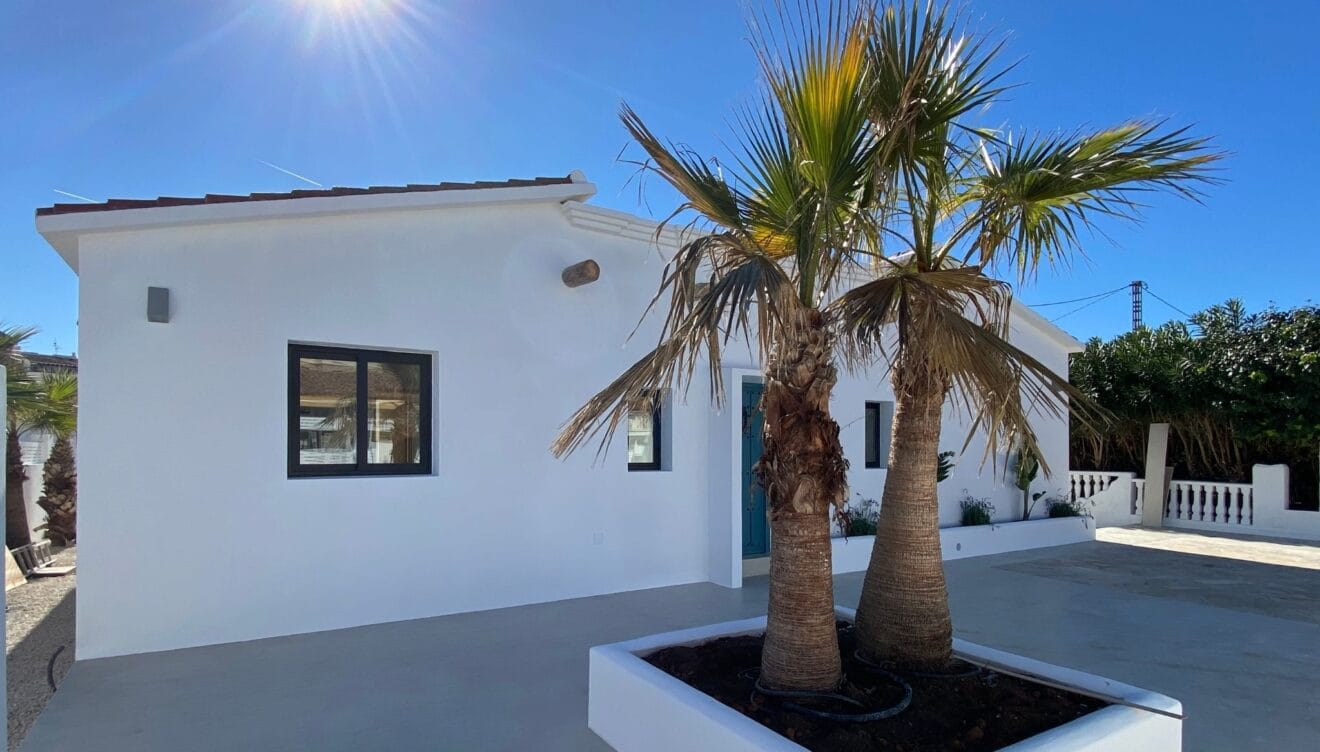 Vivienda unifamiliar reformada con palmeras en la entrada
