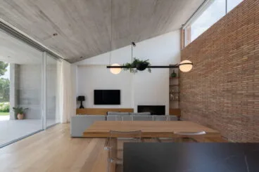 Cocina abierta al salón-comedor con paredes de ladrillo
