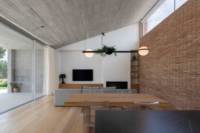 Cocina abierta al salón-comedor con paredes de ladrillo