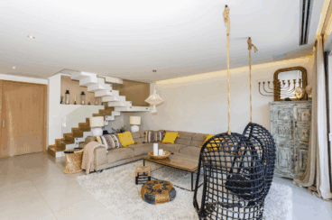 Salón de la villa de estilo boho con sillas colgantes