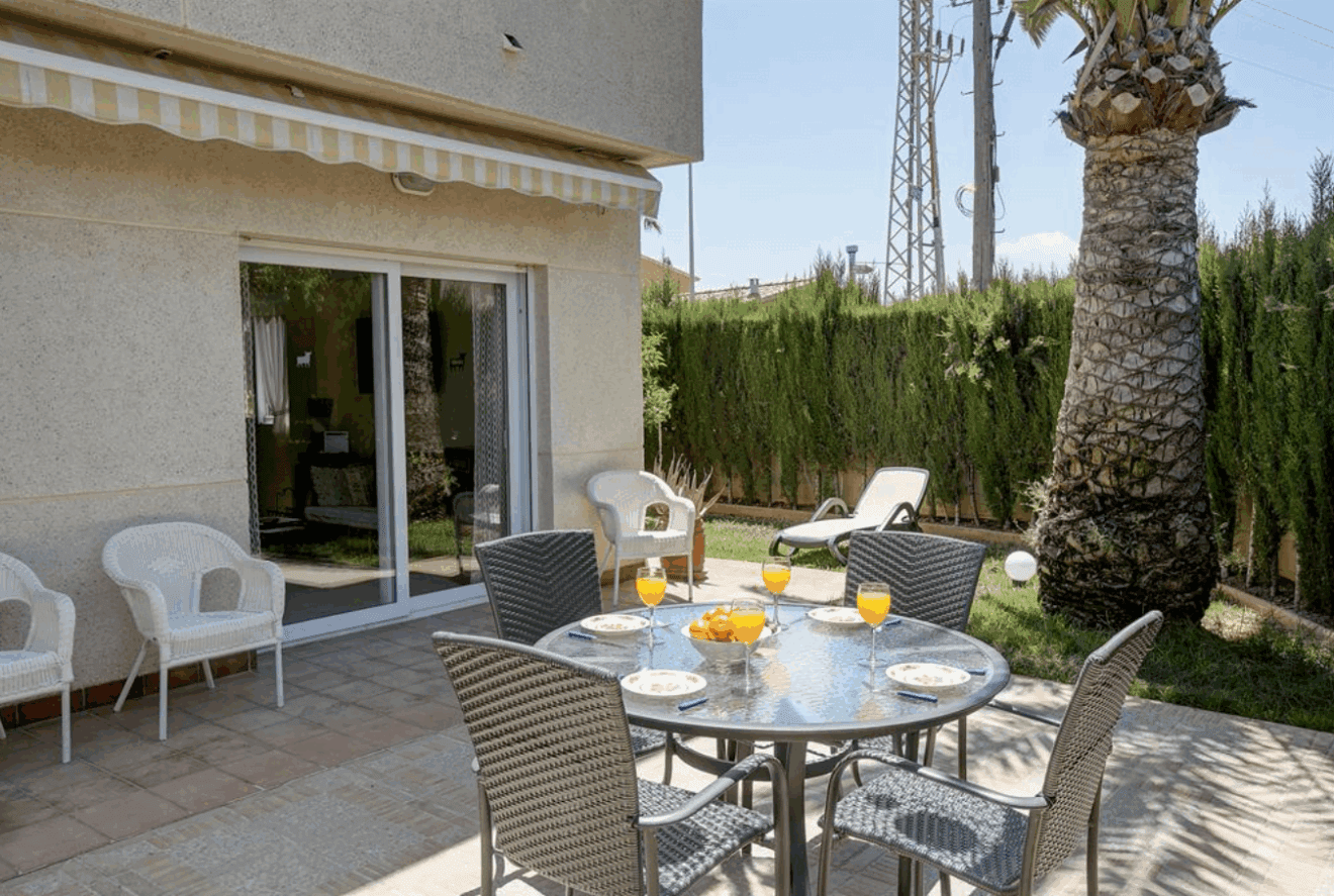 Terraza con conjunto de comedor exterior del adosado