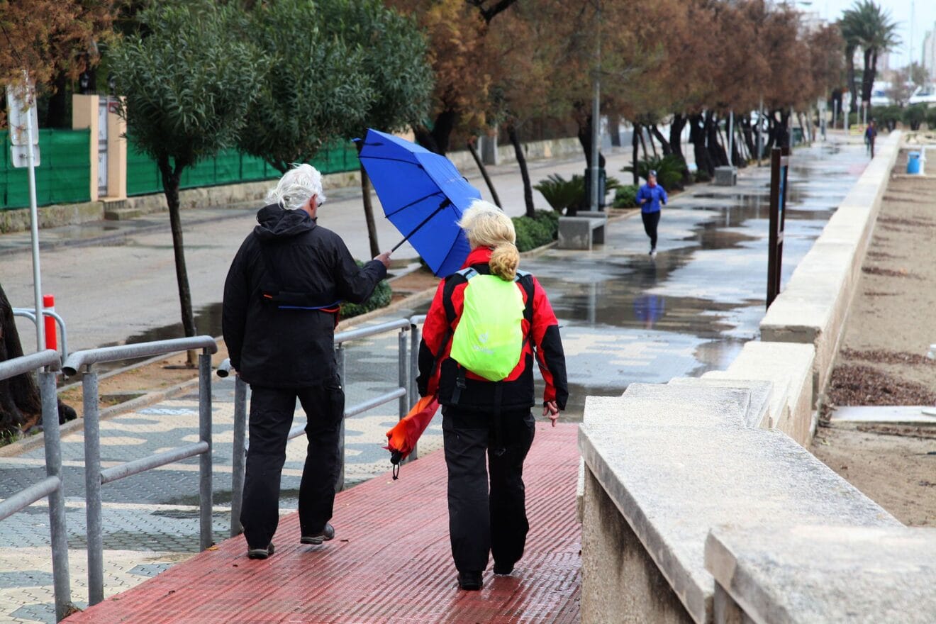 Viandantes por la Marineta de Dénia durante la tormenta del viernes