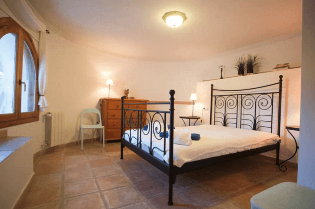 dormitorio con cama de matrimonio y estructura de metal