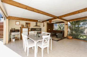 Zona de comedor exterior cubierto con barbacoa
