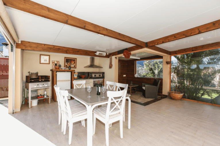 Zona de comedor exterior cubierto con barbacoa