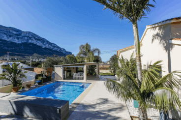 Zona de la piscina con comedor exterior cubierto