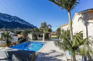 Zona de la piscina con comedor exterior cubierto