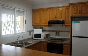 Cocina con muebles de madera y barra americana