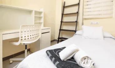 Dormitorio con cama individual y escritorio