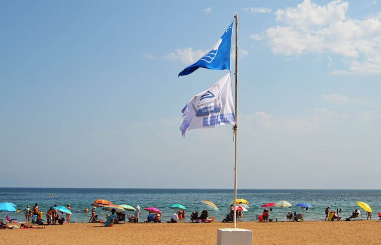 La bandera azul hondeando en la playa de Les Bovetes de Dénia