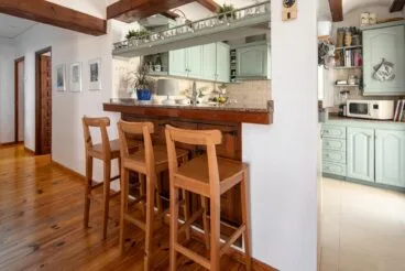 Barra con taburetes conectada a la cocina