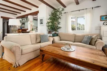 Salón estilo rústico con sofás color crema y mesa de madera
