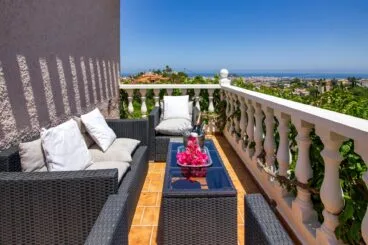 Terraza lateral con conjunto de ratán con vistas al mar
