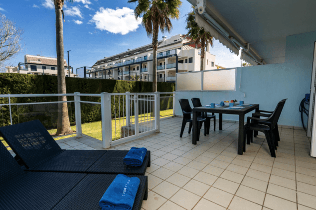 amplia terraza junto al jardin con zona cubierta