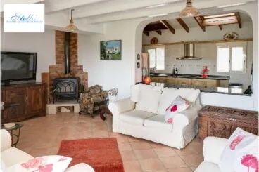 Salón comedor con cómodos sofás para ver la TV y estufa de leña