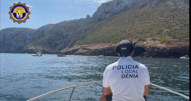 Agente de la Policía Local de Dénia de patrulla y varias embarcaciones fondeadas ilegalmente en el fondo