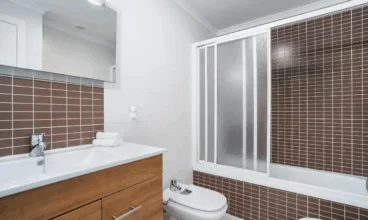 Baño con bañera y mampara de cristal