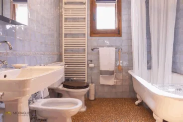 Baño rústico con suelo empedrado y bañera