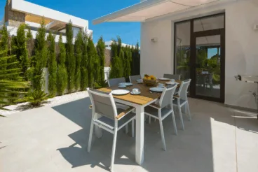 Comedor exterior de la vivienda con toldo