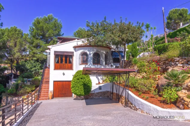 Vivir en plena conexión con la naturaleza: así es la espectacular villa rústica en venta en El Montgó 10 fachada de la vivienda con garaje y pergola para tus vehiculos