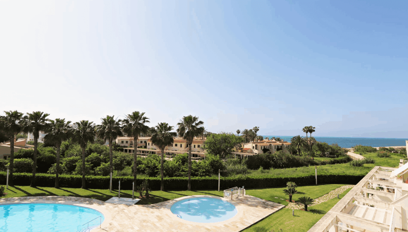 Jardines de la vivienda junto al mar con piscina comunitaria