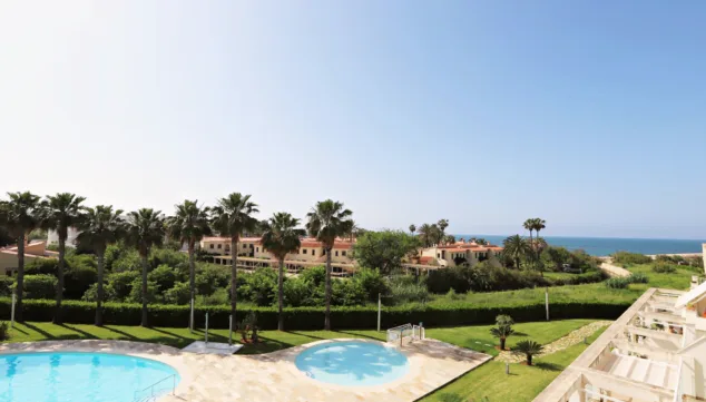 El luminoso apartamento con vistas al mar en Dénia al que no te podrás resistir 2 Imagen: Jardines de la vivienda junto al mar con piscina comunitaria