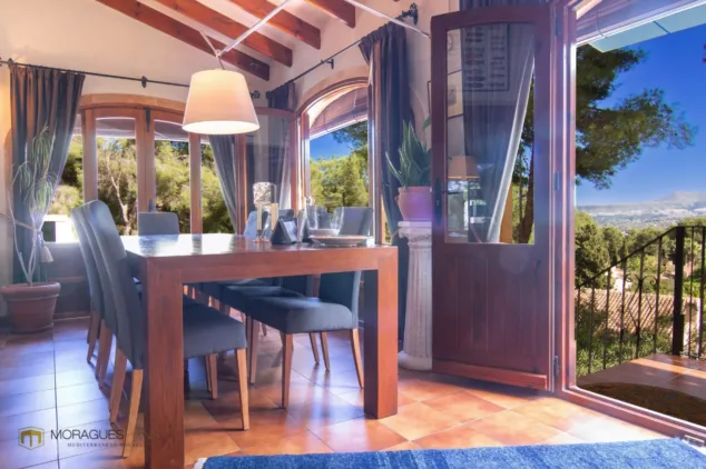 Vivir en plena conexión con la naturaleza: así es la espectacular villa rústica en venta en El Montgó 5 zona de comedor con vistas espectaculares a la montancc83a y una messa para 10 personas