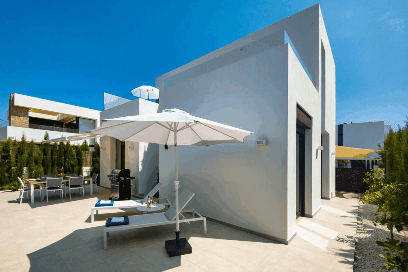 Zona de comedor exterior con barbacoa y tumbonas